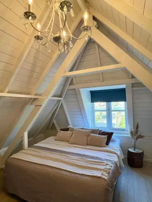 a bedroom with a large bed in the attic at Rhynhoven Lodge in Hazerswoude-Rijndijk