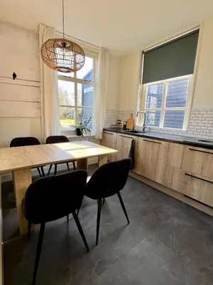 a kitchen with a table and chairs in a room at Rhynhoven Lodge in Hazerswoude-Rijndijk