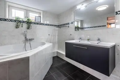 a white bathroom with a tub and a sink at Spacious 120m2 Water Villa With Sauna Near Amsterdam in Aalsmeer