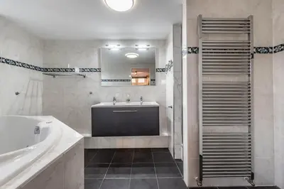 a bathroom with a tub and a sink and a mirror at Spacious 120m2 Water Villa With Sauna Near Amsterdam in Aalsmeer