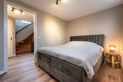 a bedroom with a large bed and a staircase at Spacious 120m2 Water Villa With Sauna Near Amsterdam in Aalsmeer