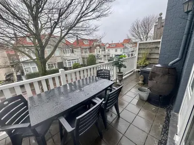 a table and chairs on the balcony of a house at Seastreet Suite in Zandvoort