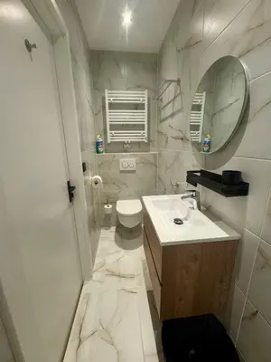 a white bathroom with a sink and a toilet at Seastreet Suite in Zandvoort