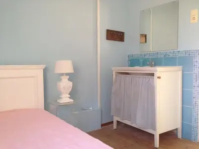 a bedroom with a bed and a mirror and a lamp at Pacific Ocean View Comfortable Holiday Residence in Bergen aan Zee