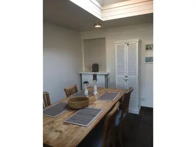 a dining room with a wooden table and chairs at Pacific Ocean View Comfortable Holiday Residence in Bergen aan Zee