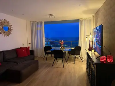 a living room with a couch and a table with chairs at Rosalie Apartment in Zandvoort