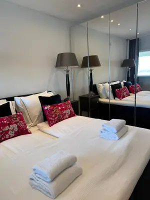 two beds in a room with mirrors at Rosalie Apartment in Zandvoort
