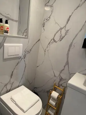 a bathroom with a black and white marble wall at Rosalie Apartment in Zandvoort