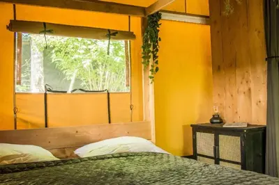 a bedroom with a bed and a window in it at Zorgcamping De Ruif De Peppelhoeve in Stoutenburg