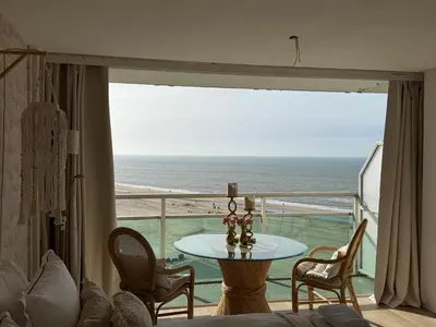 a room with a table and a view of the ocean at Studio Michelle in Zandvoort
