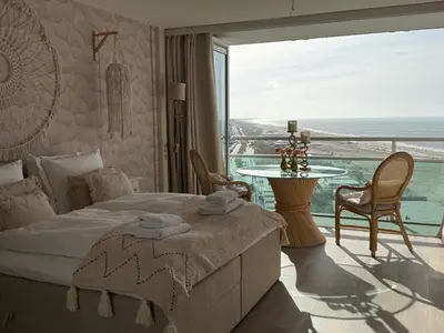 a bedroom with a bed and a view of the ocean at Studio Michelle in Zandvoort
