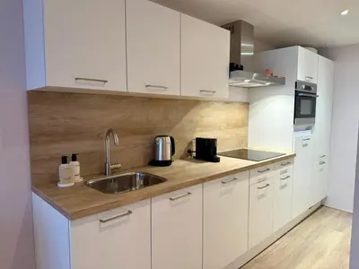 a kitchen with white cabinets and a sink at Studio Michelle in Zandvoort