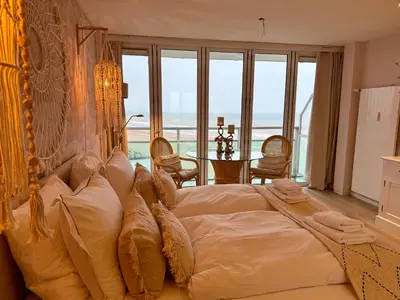 a bedroom with a large bed with a view of the ocean at Studio Michelle in Zandvoort