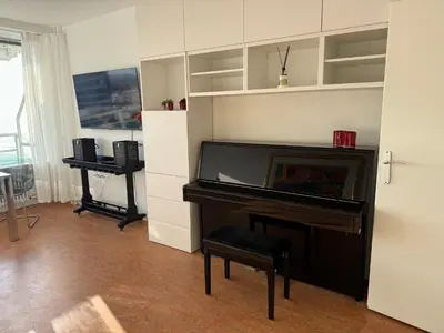 a living room with a piano and a desk at Piano Apartment in Zandvoort