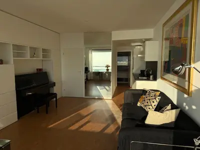 a living room with a couch and a piano at Piano Apartment in Zandvoort