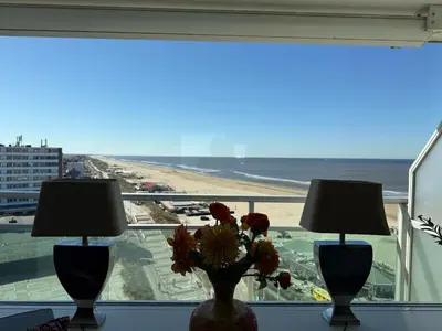 two lamps on a window with a view of the beach at Piano Apartment in Zandvoort