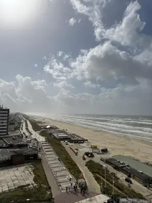 a view of a beach and the ocean on a cloudy day at Piano Apartment in Zandvoort