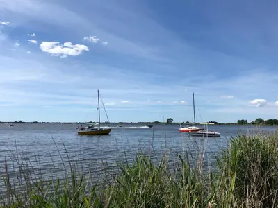 three boats in a large body of water at Glampingtent de Deiling, de Woudhaven in De Woude