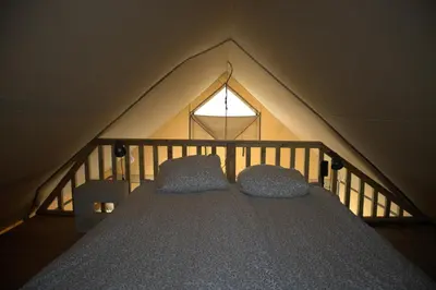 a bed in a tent with two pillows on it at Glampingtent de Deiling, de Woudhaven in De Woude