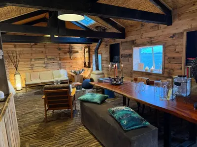 a living room with a table and a couch at The Historical Trick Hut in the middle of the Lake in Baambrugse Zuwe