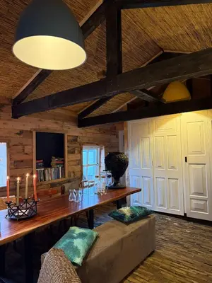 a living room with a wooden table and a couch at The Historical Trick Hut in the middle of the Lake in Baambrugse Zuwe