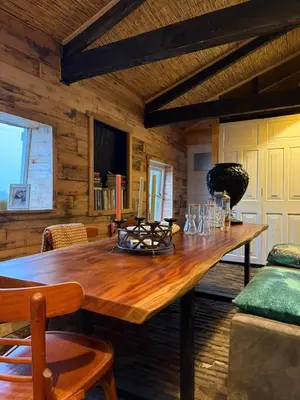 a large wooden table in a room with wooden walls at The Historical Trick Hut in the middle of the Lake in Baambrugse Zuwe