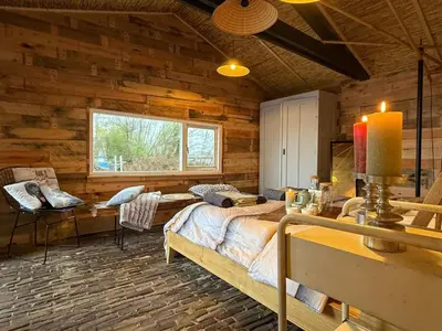 a bedroom with a bed in a log cabin at The Historical Trick Hut in the middle of the Lake in Baambrugse Zuwe