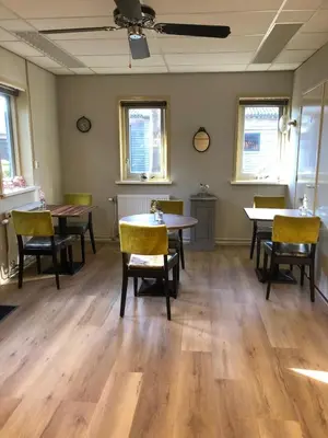 a dining room with tables and chairs and windows at Bed en Breakfast 1394 in Nederhorst den Berg