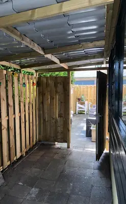 a patio with wooden walls and a fence at Bed en Breakfast 1394 in Nederhorst den Berg