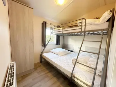 a bedroom with two bunk beds in a room at Chalet 7a op Recreatiepark De Wielen in Sint Maarten