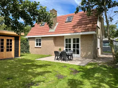 a house with a table and chairs in the yard at Zon aan den Hoef by Droomvilla in Egmond aan den Hoef