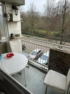 a balcony with a table and chairs and a view of a street at B&B Calypso Amsterdam in Amsterdam