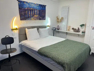 a bedroom with a bed and a painting on the wall at Leoicom in Zandvoort