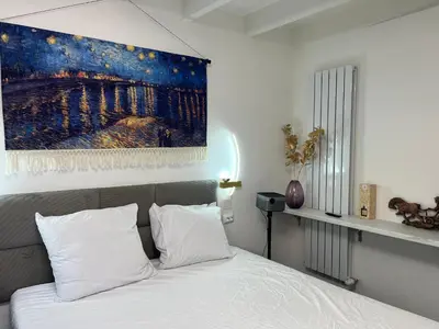 a bedroom with a bed with a painting above it at Leoicom in Zandvoort
