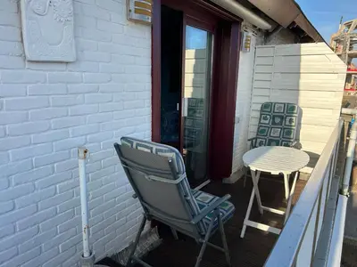 a rocking chair and a table on a porch at Leoicom in Zandvoort
