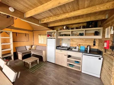 a kitchen and living room of a tiny house at Glampingtent de Saskerlei, de Woudhaven in De Woude