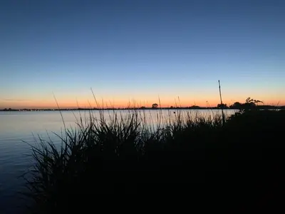 a view of a body of water at sunset at Glampingtent de Saskerlei, de Woudhaven in De Woude