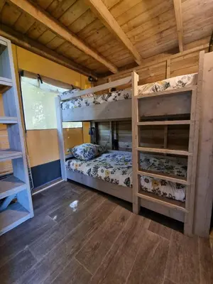 a bedroom with two bunk beds in a house at Glampingtent de Saskerlei, de Woudhaven in De Woude