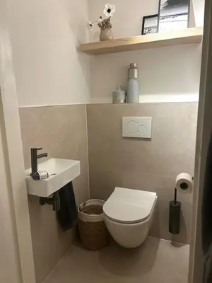 a small bathroom with a toilet and a sink at Have a nice stay! - Duinloft 150 m from the beach in Noordwijk