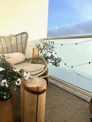 a room with a wicker chair and a plant at Have a nice stay! - Duinloft 150 m from the beach in Noordwijk