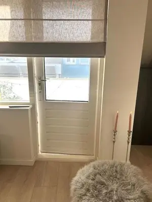 a room with a door and a window with a blind at Have a nice stay! - Duinloft 150 m from the beach in Noordwijk