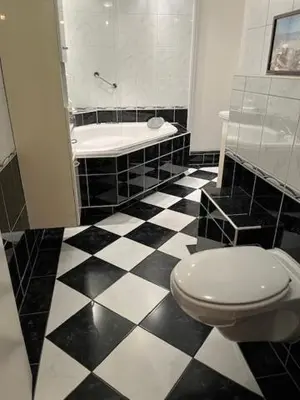 a black and white bathroom with a toilet and a tub at Quarles 80 - free parking in Noordwijk aan Zee