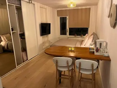 a living room with a table and chairs and a bed at Quarles 80 - free parking in Noordwijk aan Zee