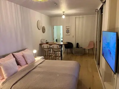a bedroom with a bed and a tv and a table at Quarles 80 - free parking in Noordwijk aan Zee