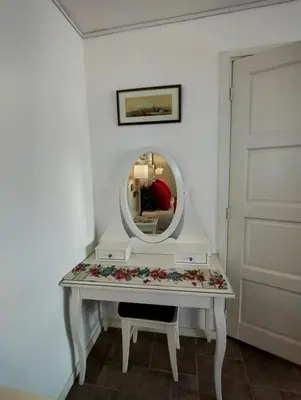 a dressing table with a mirror and flowers on it at La Veranda in Zandvoort