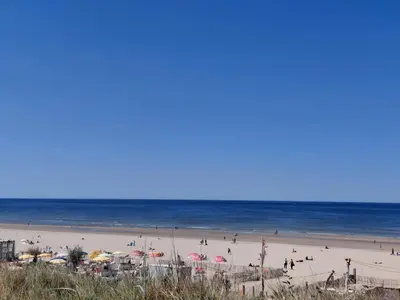 a group of people on a beach with umbrellas at La Veranda in Zandvoort