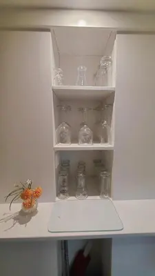 a white cabinet with glass jars and a vase at La Veranda in Zandvoort