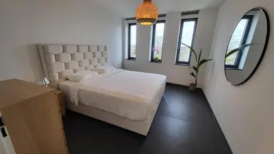 a bedroom with a large bed and a mirror at B&B Kopwest 8 personen in Purmerend