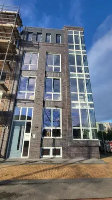 a tall brick building with lots of windows at B&B Kopwest 8 personen in Purmerend
