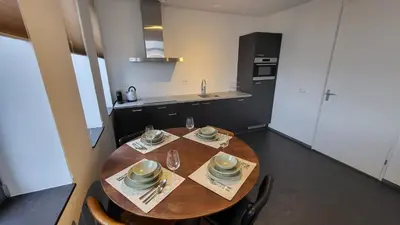 a kitchen with a wooden table with dishes on it at B&B Kopwest 8 personen in Purmerend